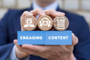 Close up to hands of a man holding wooden blocks with icons and the term Engaging Content