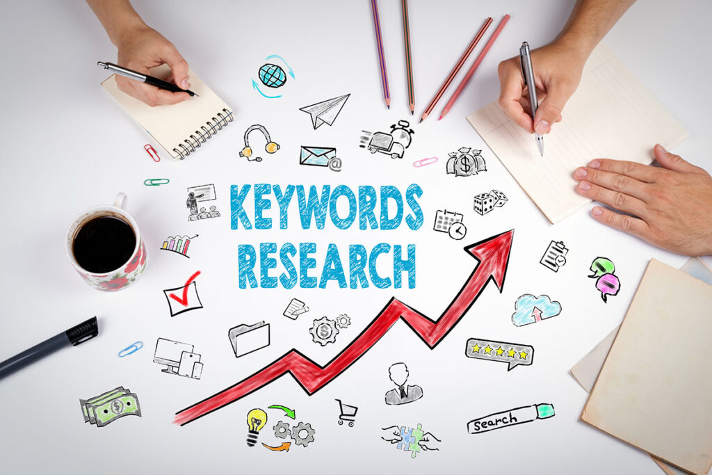 Keyword research painted on a table with people's hands in relation to SEO work.