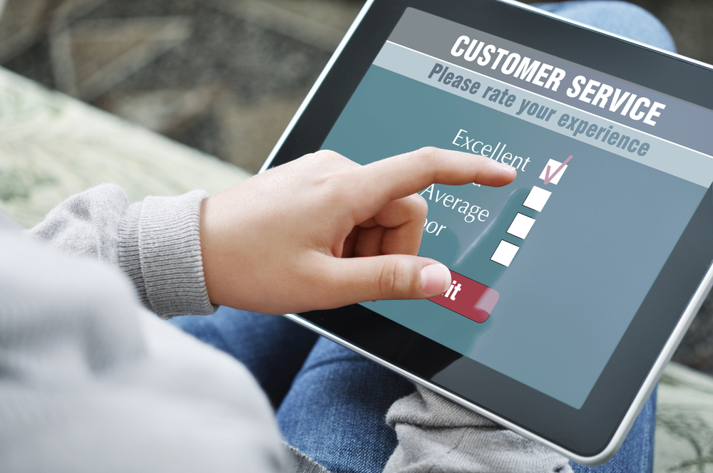 Customer selecting 'Excellent' on a digital customer service satisfaction survey on a tablet.