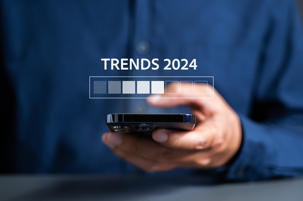 Person using smartphone with graphic overlay reading 'TRENDS 2024'.