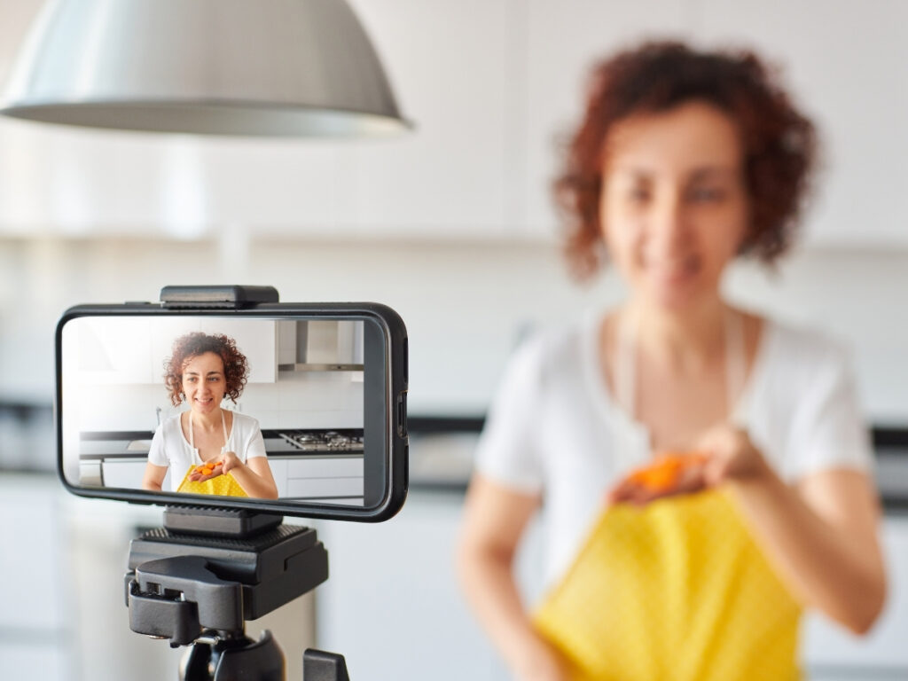 Blogger recording a kitchen tutorial video, merging SEO and visual content.